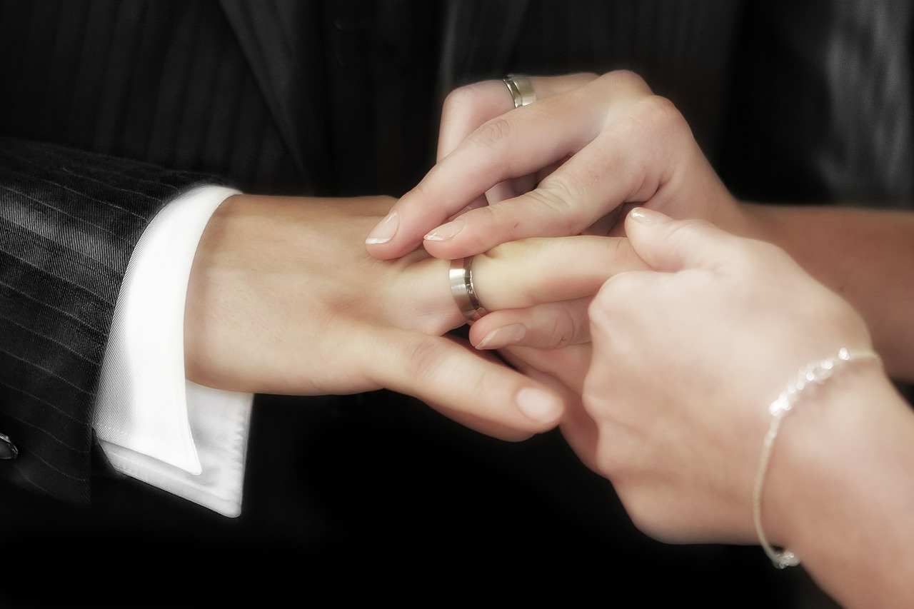 Обручальное кольцо на руке парня и девушки